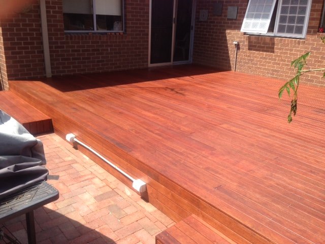Timber deck and steps beside a brick home